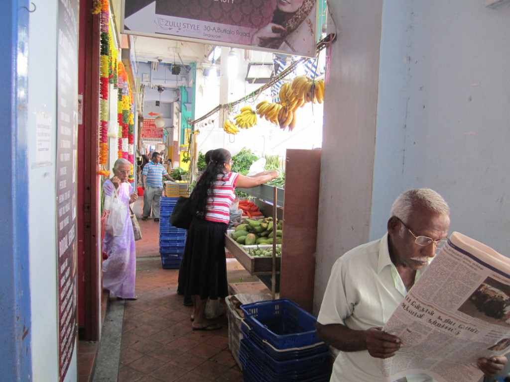 A man reads the newspaper in Little India.